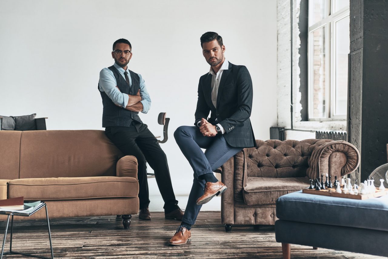 men-with-a-great-style-two-young-handsome-men-in-suits-looking-at-camera-while-resting-indoors